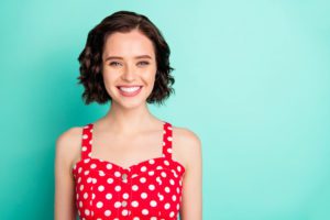 Close up portrait of fascinating young, beautiful wonderful lady posing in front of came while isolated with teal background