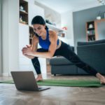 Fit woman doing side lunges indoors in a flat