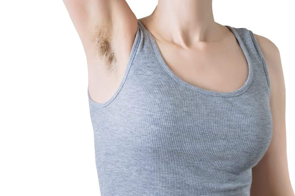 Caucasian woman in a gray singlet with an unshaven armpit. White isolate.