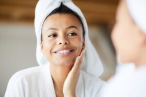 Beautiful young woman admires her clear complexion free of acne scars.