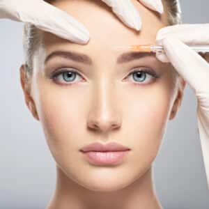 Blonde woman receives Dysport to keep her forehead smooth.